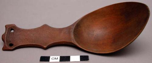 Spoon, carved wood, handle flat one side, with curved edges, and two perforation