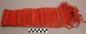 Sash, woven fiber, red with black and brown stripes, fringed ends