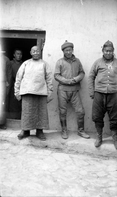 Three men in front of doorway