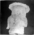 Ceramic? figurine, standing human, headdress, hand at waist. E-5, III, 8-Bis