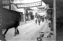 People walking on road, banners hanging between buildings