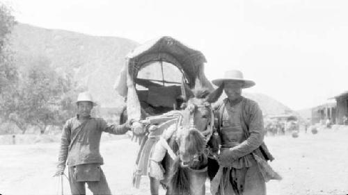 Two people with horse pulling cart