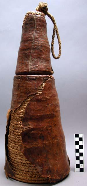 Tall conical basket and cover, completely covered with leather, torn