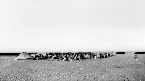 Crowd of people by a tent in the desert