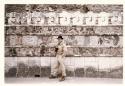 Gordon Willey standing in front of a wall of carved frieze