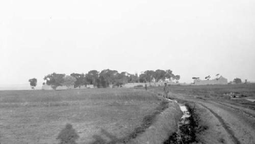 Man standing by stream running through field