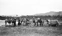 People and horses at edge of river