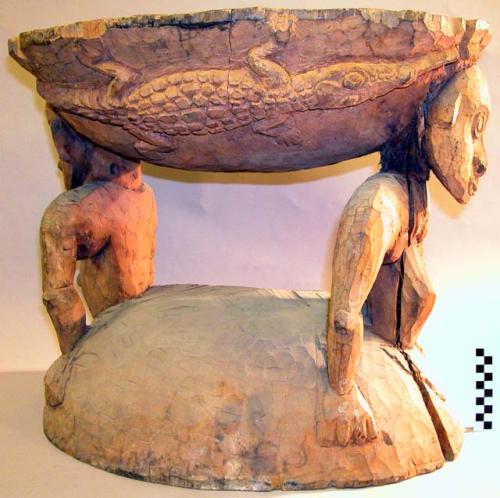 Large wooden stool with two carved heads