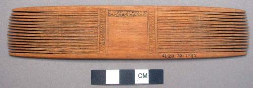 Wooden comb - solid center, comb on both ends, carved; used by both +