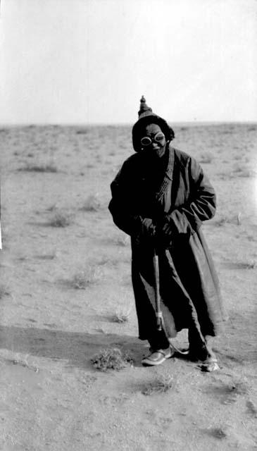 Person with pointed hat standing in desert