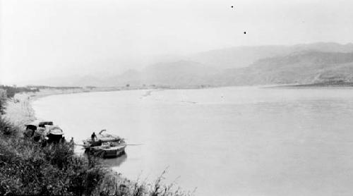 Person in boat on lake by mountains