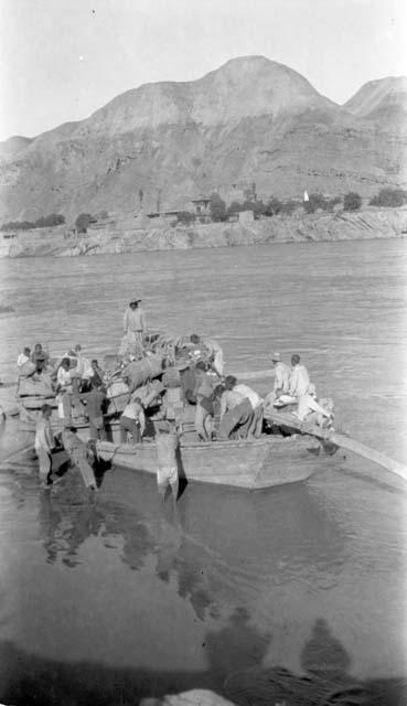 Men packing boat in river