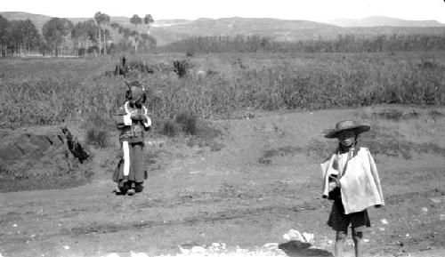 Children on dirt road near field