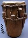 Drum, cylindrical wood body, skin head bound with fiber, wood pegs around edge