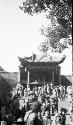 People in front of a building with a pointed, tiled roof