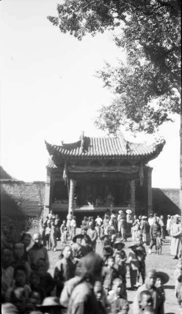 People in front of a building with a pointed, tiled roof