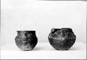 2 shoe-shaped vessels with faces, redish brown