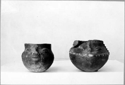 2 shoe-shaped vessels with faces, redish brown