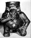 Ceramic effigy jar, zoomorph kneeling and holding snout, dark slip