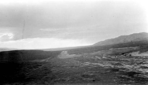 Barren, rocky road, hills in background