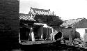 Woman (Janet Wulsin?) in courtyard with wagon and supplies