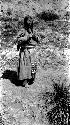 Barefoot Tibetan woman standing on road