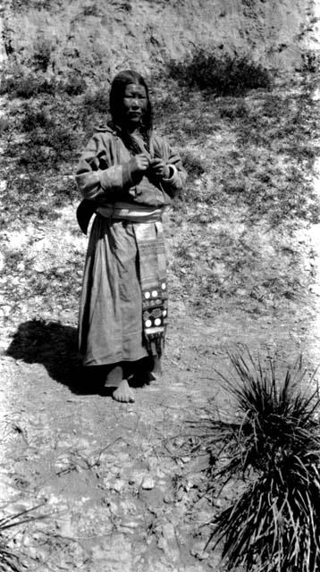 Barefoot Tibetan woman standing on road