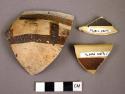 Ceramic rim and body sherds, black on yellow ware, linear design