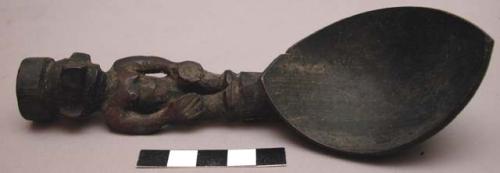 Wooden spoon, handle carved in human effigy: hands resting on flexed knees, shor