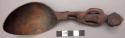 Wooden spoon, handle carved in human effigy: hands resting on flexed knees, deco