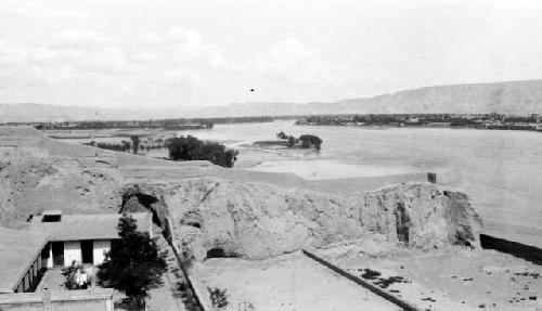 Building by river, mountains in background