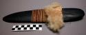 Ground stone blade, flat, thin, wrapped around center with fiber and fur