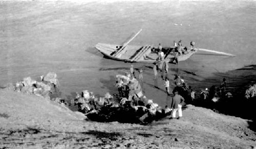 Men in and near boat in river