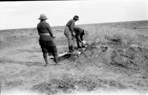 Three people standing in desert