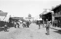 People walking down a street, with Gu Lou in the background