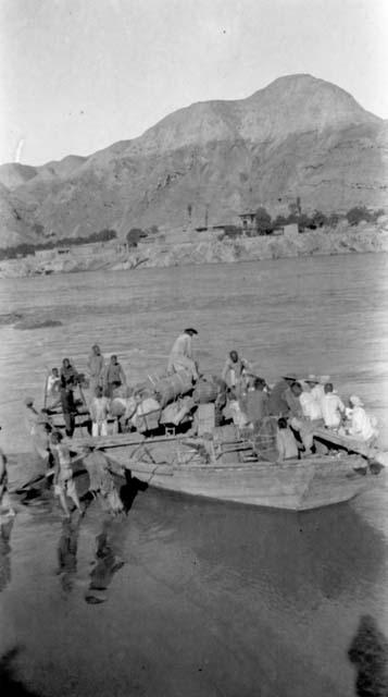 Men in and beside boat in river