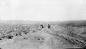 Person with umbrella walking in desert