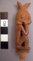 Stopper, carved wood, for miniature jar, seated human effigy with hands on face