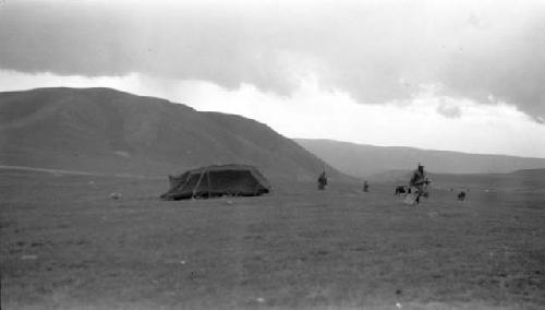 People by a tent near mountains