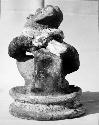 Pot 17, Grave 2. Pottery figure seated on low platform holding a small bowl