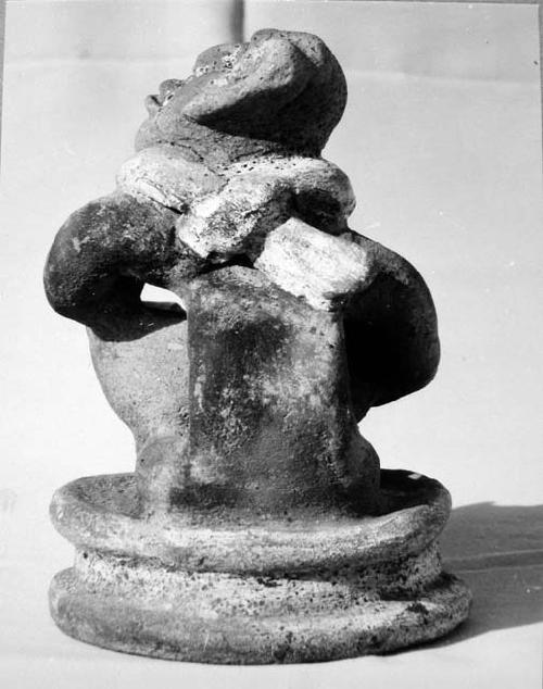 Pot 17, Grave 2. Pottery figure seated on low platform holding a small bowl