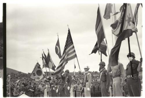 Representatives from nations who participated in the Korean combat raising flags during a Memorial Day ceremony to honor United Nations soldiers killed in the Korean War