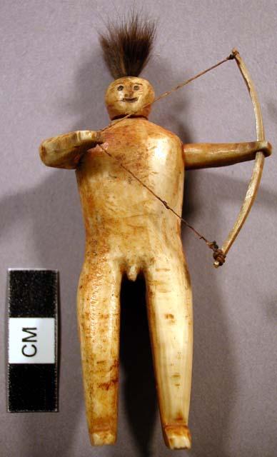 Carving of human holding a bow. Made of ivory and sinew for bow.