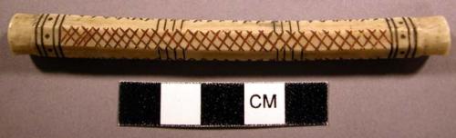 Needle case, bone and pigment. Hollow bone tube, slightly notched on both ends.