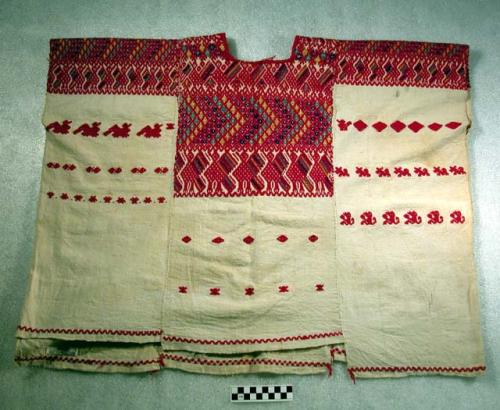 Huipil. white with red, yellow, green, blue, and purple embroidery. 79 x 63 cm.