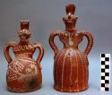 2 effigy vessels, female figure. red ware, white painted decoration. 24 cm. tall