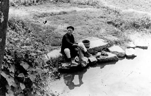 Woman washing clothes in river