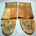 Pair of long legged moccasins of hide painted around top and on foot