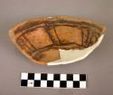 Fragments of jeddito black on yellow pottery bowl