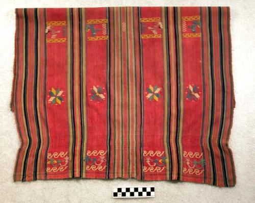 Small tzute. red with blues, green, yellow, pink, and white embroidery. 55 x 73